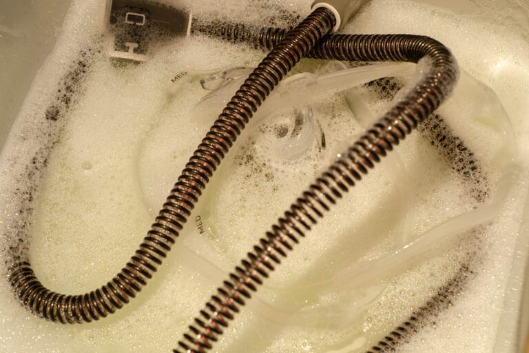 CPAP equipment in sink for cleaning with soap