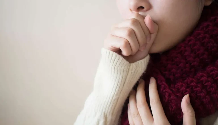 woman coughing into her hand, possibly showing mold symptoms